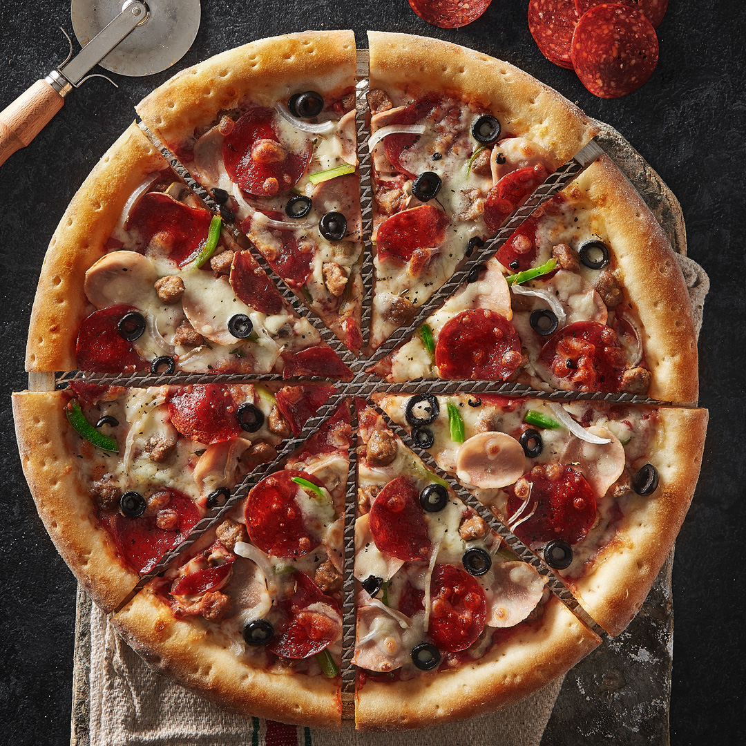 Broccoli pizza photographed with pepperoni, olives and mushrooms